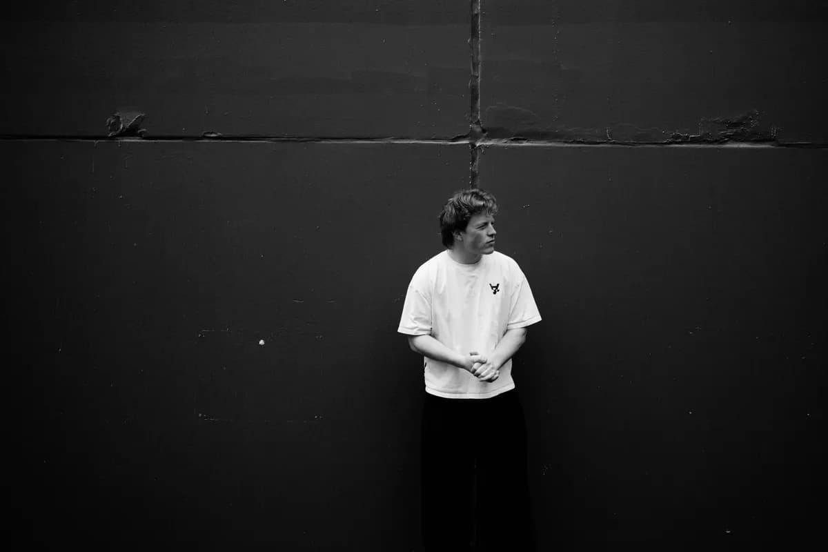 Sunday standing against a dark concrete wall